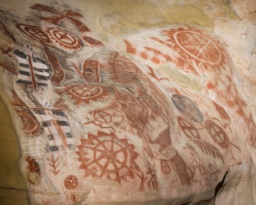 Petroglyphs at Chumash Painted Cave State Historic Park, high above Santa Barbara, California.  The walls of a single small cave carved from towering sandstone boulders contain some of the finest remaining rock art created by Chumash Native Americans.  A steep path leads to the cave entrance, which is protected by heavy iron grillwork, due to vandalism by thoughtless visitors. Anthropologists estimate that the paintings date to the 1600s and earlier.  The meaning of these enigmatic images has been lost.