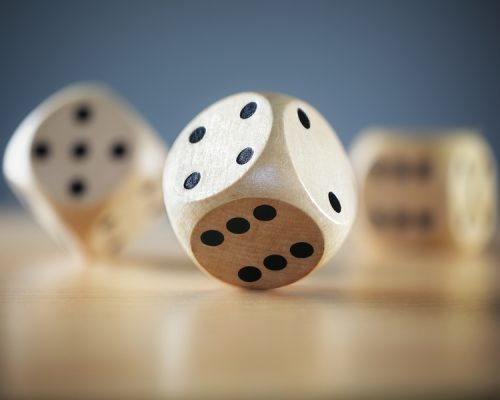 Rolling three dice on a wooden desk